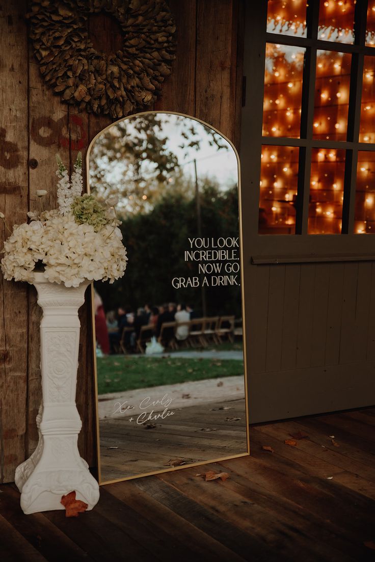 Large arched gold mirror sign with warm lighting